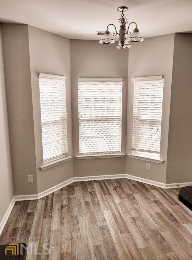 1208 Bordeau Way, Villa Rica, GA 30180 - empty room with an inviting chandelier, dark hardwood / wood-style floors, and a healthy amount of sunlight