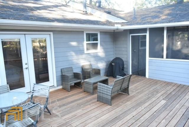 wooden terrace with a sunroom and a grill