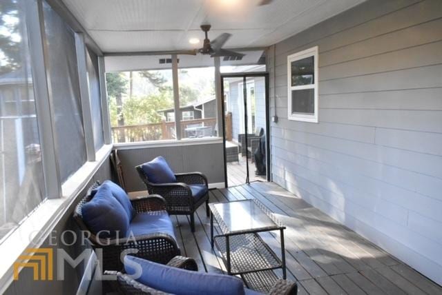 sunroom / solarium featuring ceiling fan