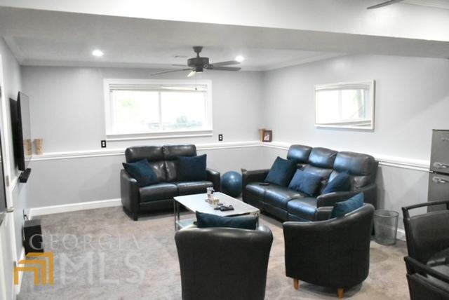 living room with ceiling fan and light carpet