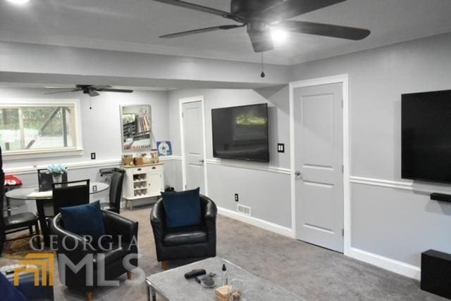 carpeted living room with ceiling fan