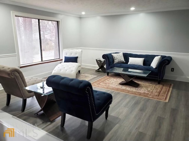 living area featuring a textured ceiling, ornamental molding, and hardwood / wood-style flooring