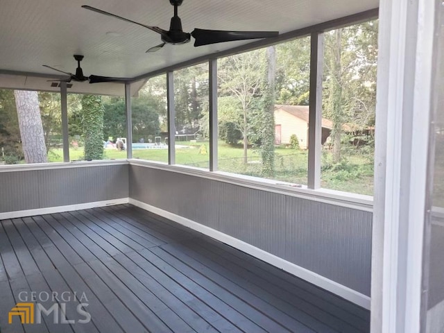 unfurnished sunroom with ceiling fan