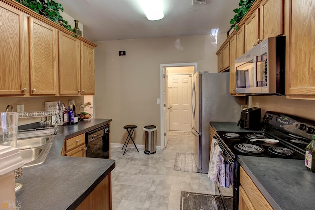 kitchen with light tile floors, black appliances, and sink