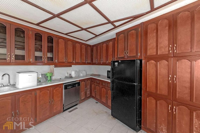 kitchen featuring stainless steel dishwasher, black refrigerator, and light tile flooring