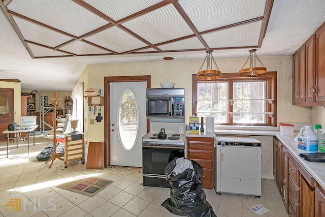 kitchen with white range with electric cooktop, decorative light fixtures, washer / dryer, and light tile floors