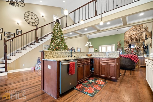 kitchen featuring coffered ceiling, stainless steel dishwasher, pendant lighting, dark hardwood / wood-style floors, and light stone counters