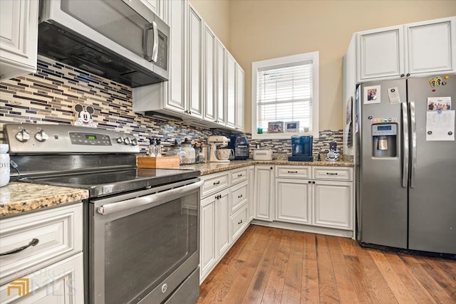 kitchen with white cabinetry, tasteful backsplash, appliances with stainless steel finishes, and dark hardwood / wood-style floors