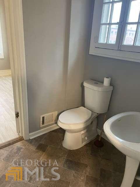 bathroom featuring tile flooring and toilet