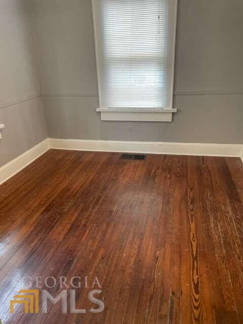 unfurnished room with dark hardwood / wood-style floors