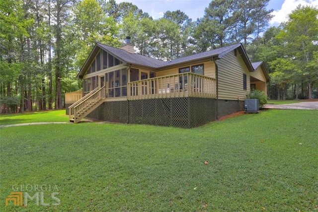 view of front of property with central AC unit, a wooden deck, a front lawn, and a sunroom