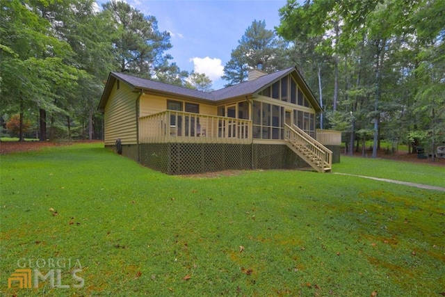 back of property featuring a lawn and a sunroom