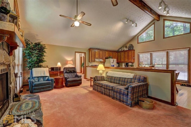 living room with ceiling fan, a fireplace, track lighting, high vaulted ceiling, and light carpet