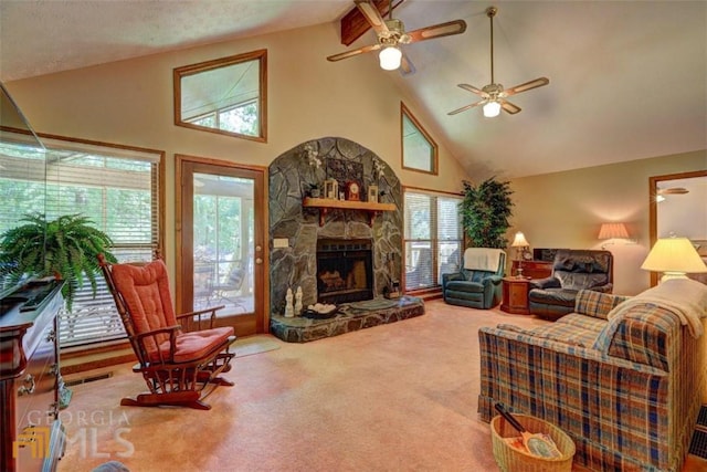 carpeted living room featuring ceiling fan, a wealth of natural light, high vaulted ceiling, and a stone fireplace