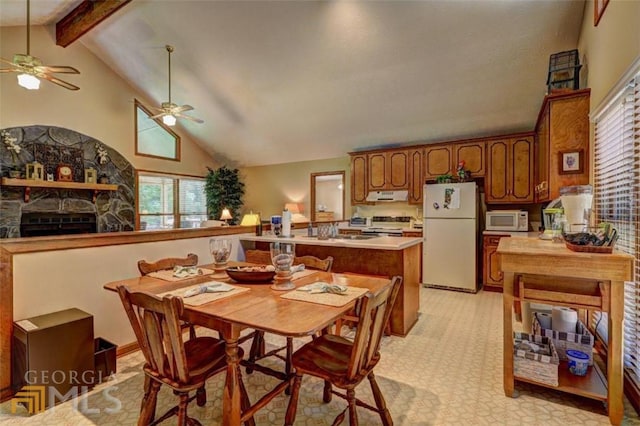 interior space featuring high vaulted ceiling, ceiling fan, beamed ceiling, a stone fireplace, and sink