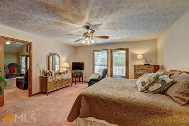 bedroom with ceiling fan, a textured ceiling, and light colored carpet