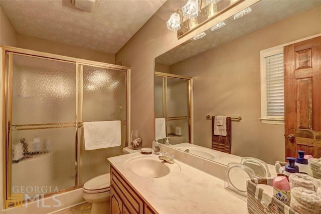 bathroom featuring walk in shower, toilet, vanity, and a textured ceiling