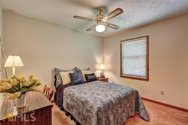 carpeted bedroom with ceiling fan and a textured ceiling