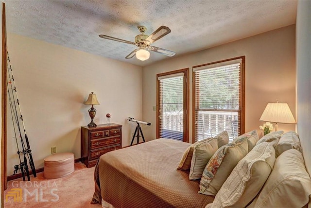 carpeted bedroom with ceiling fan and a textured ceiling