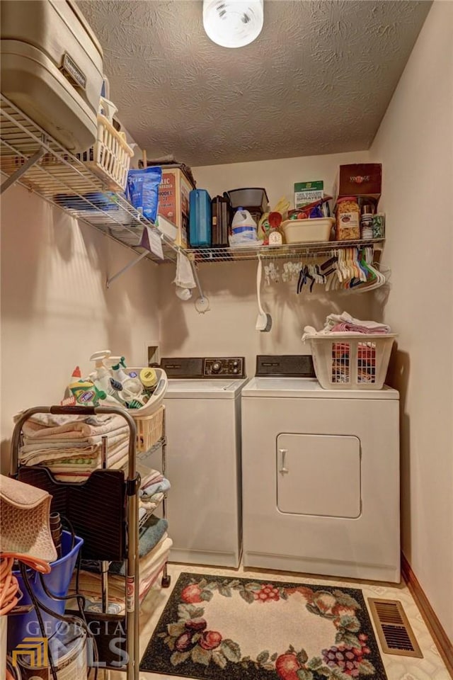 washroom with a textured ceiling and washer and clothes dryer