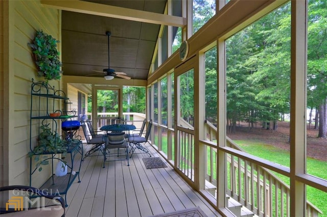 unfurnished sunroom with ceiling fan and vaulted ceiling