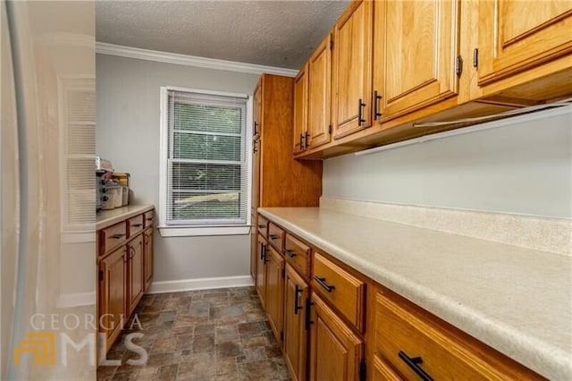 kitchen featuring ornamental molding, dark tile floors, and a textured ceiling