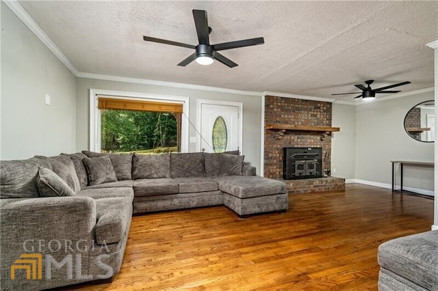 living room featuring a fireplace, a textured ceiling, ceiling fan, and light wood-type flooring