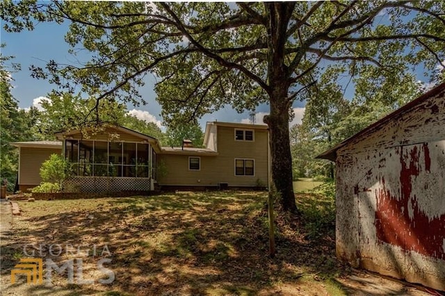 rear view of property featuring a sunroom