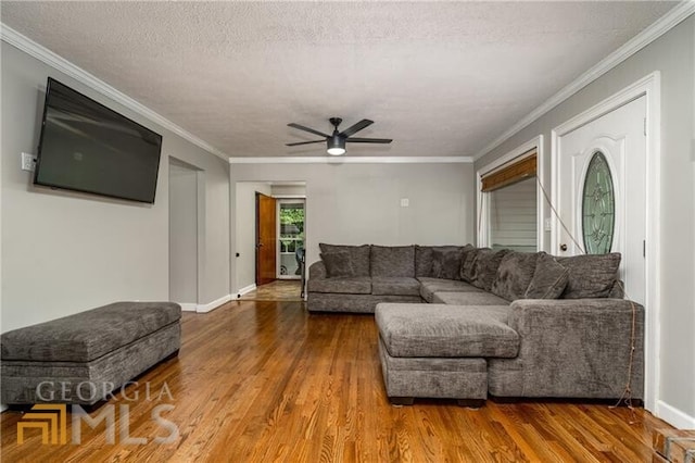 living room with ceiling fan, crown molding, and wood-type flooring