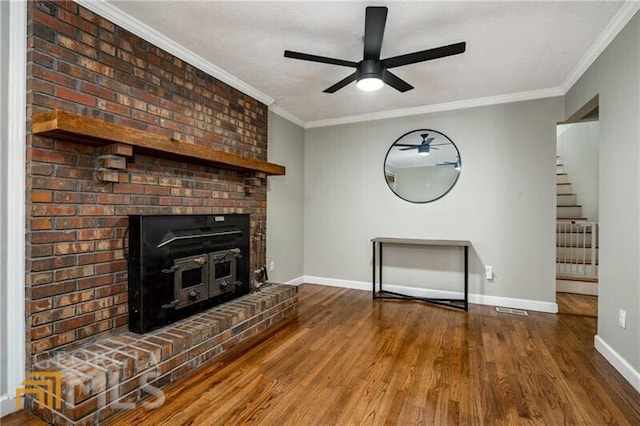 unfurnished living room with brick wall, a brick fireplace, ceiling fan, crown molding, and dark wood-type flooring