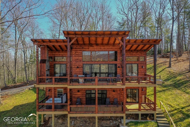 back of property featuring a wooden deck and a yard