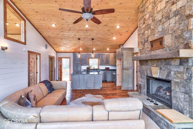 living room featuring ceiling fan, dark hardwood / wood-style flooring, wood ceiling, a fireplace, and high vaulted ceiling