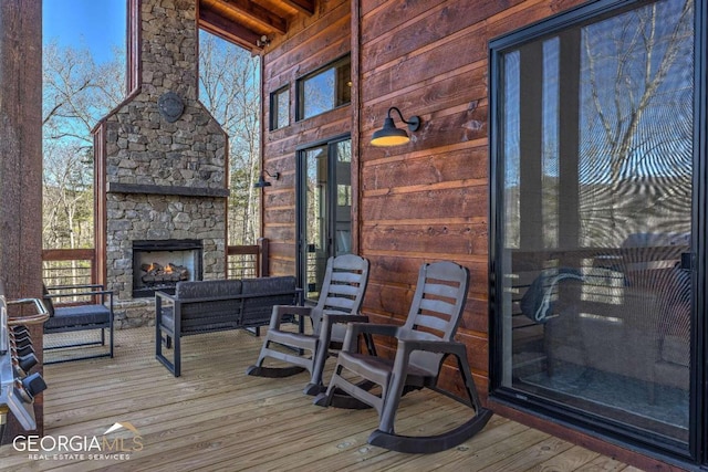 wooden deck with an outdoor living space with a fireplace