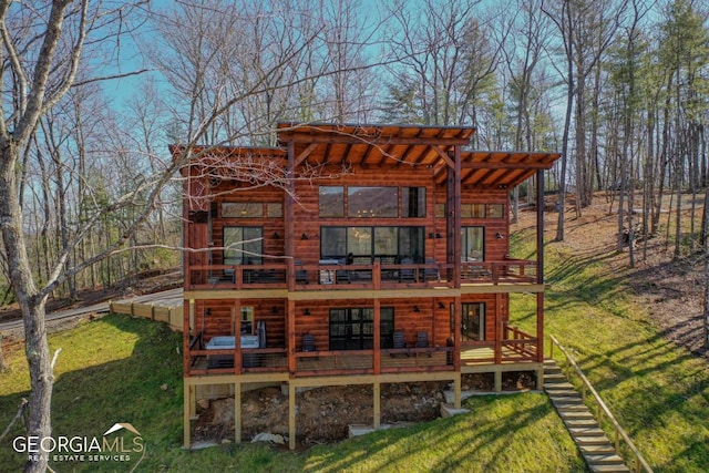 back of property featuring a lawn and a wooden deck