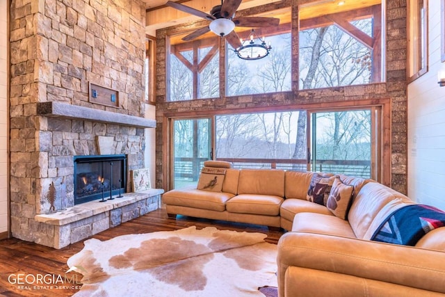 living room featuring a healthy amount of sunlight, ceiling fan, dark hardwood / wood-style flooring, and a fireplace