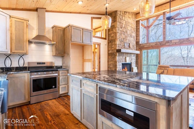 kitchen with stainless steel stove, wood ceiling, wall chimney exhaust hood, dark hardwood / wood-style flooring, and pendant lighting