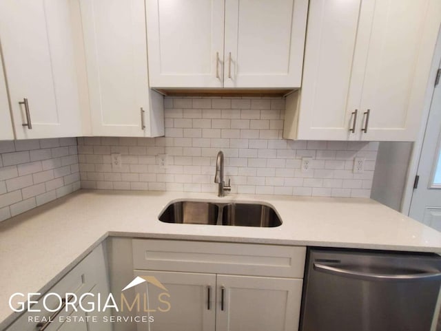 kitchen with stainless steel dishwasher, sink, and white cabinets