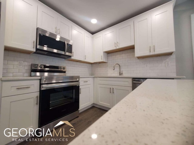 kitchen featuring appliances with stainless steel finishes, backsplash, and white cabinets