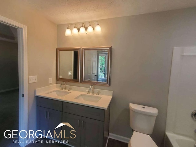 full bathroom with a textured ceiling, bathtub / shower combination, toilet, and dual bowl vanity