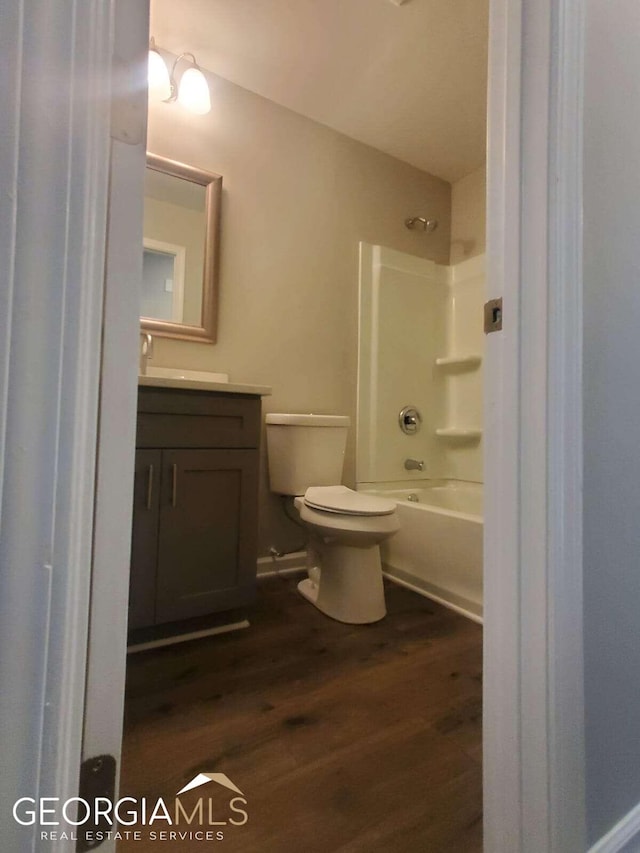 full bathroom featuring toilet, vanity, washtub / shower combination, and hardwood / wood-style floors