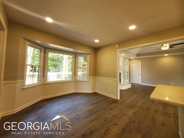 unfurnished room featuring ceiling fan, a raised ceiling, and dark hardwood / wood-style floors