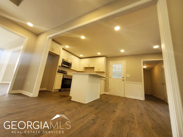 kitchen with dark hardwood / wood-style flooring, white cabinets, and stove