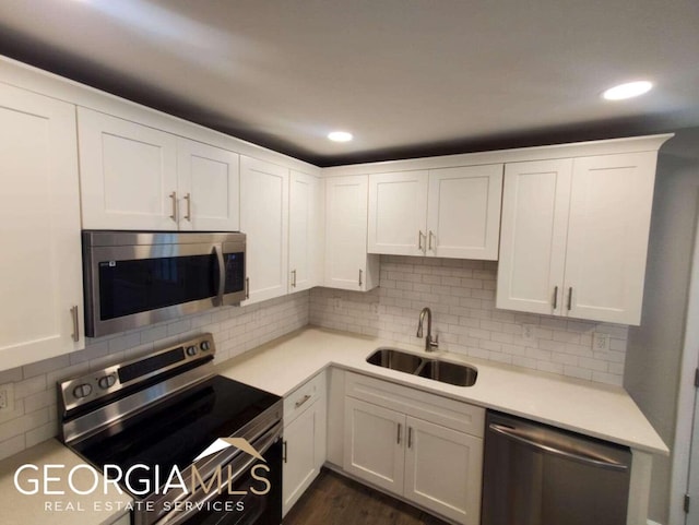 kitchen with white cabinets, backsplash, stainless steel appliances, and sink