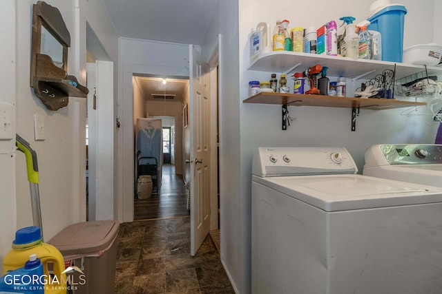 washroom with dark tile flooring and washing machine and dryer