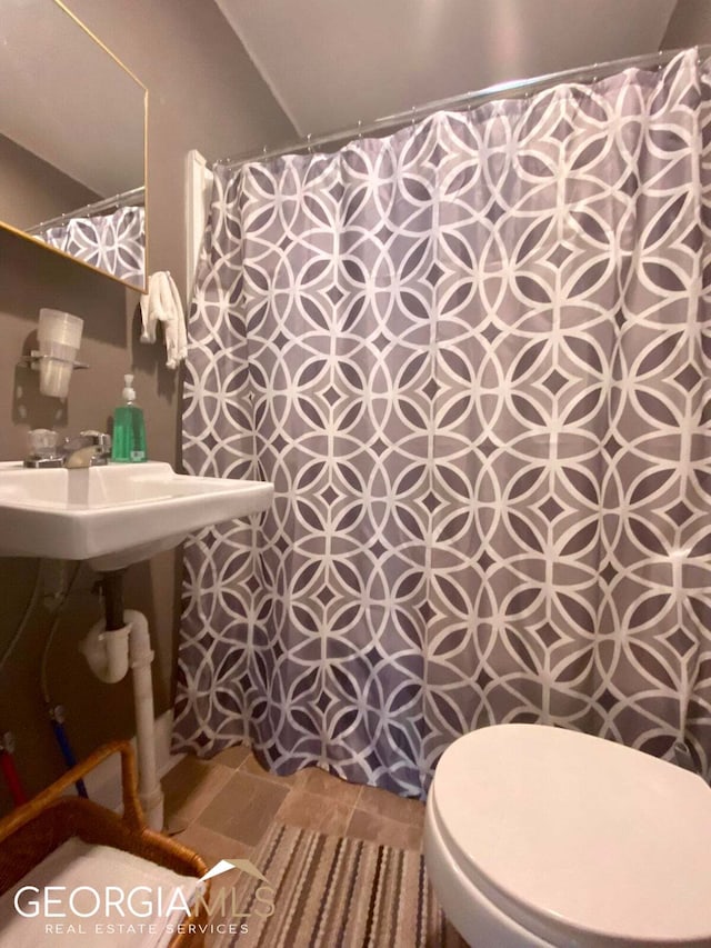 bathroom featuring lofted ceiling, toilet, and tile floors