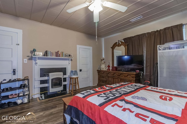 bedroom with a fireplace, ceiling fan, and dark hardwood / wood-style flooring