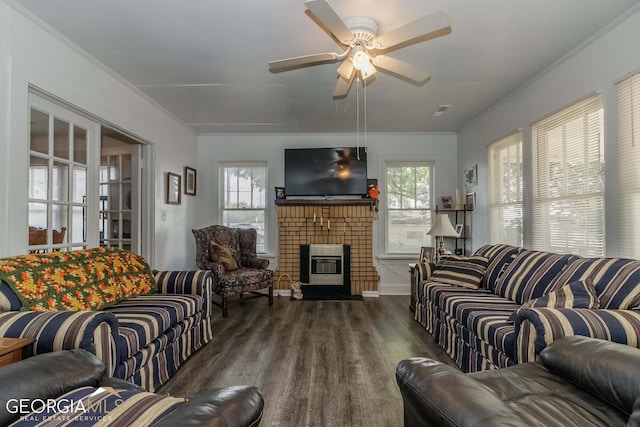 living room with crown molding, ceiling fan, dark hardwood / wood-style floors, and a fireplace