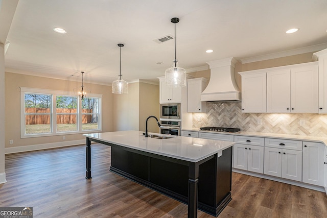 101 Bonnie Lynn Ln, Carrollton, GA 30117 - kitchen with ornamental molding, premium range hood, white cabinetry, a center island with sink, and appliances with stainless steel finishes