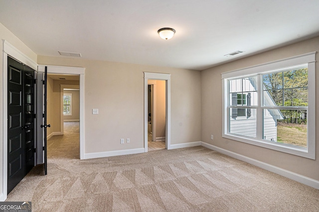 101 Bonnie Lynn Ln, Carrollton, GA 30117 - spare room featuring light carpet, plenty of natural light, visible vents, and baseboards