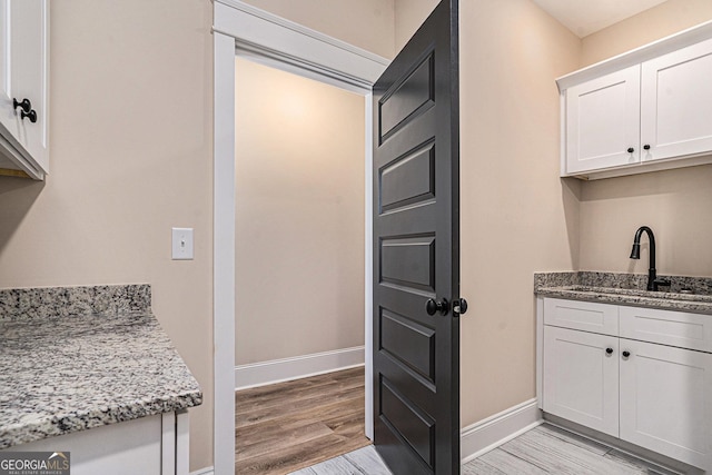101 Bonnie Lynn Ln, Carrollton, GA 30117 - kitchen with a sink, white cabinets, light wood finished floors, and light stone countertops
